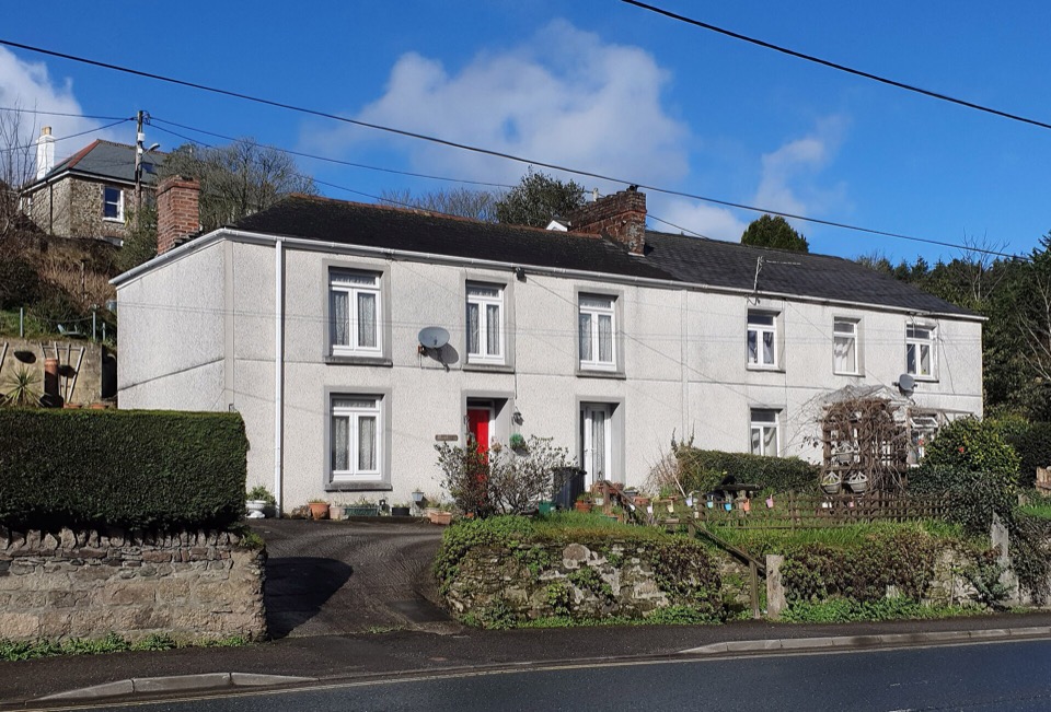 White rendered semi detached houses on Bridge Street in St Blazey, Cornwall